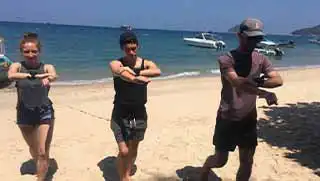 Navigation Specialty Divers practicing compass skills on land on Mae Haad beach Koh Tao