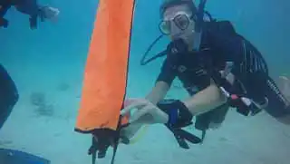 Search and Recovery specialty course diver releasing delayed surface marker buoy (DSMB)