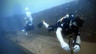 Advanced Wreck Diver Specialty course divers practicing line laying outside the HTMS Sattakut Wreck