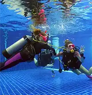 Divemaster Trainees learning to demonstrate stationary gas sharing in the pool