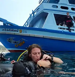 Divemaster Trainee performing rescue breath on unconscious diver