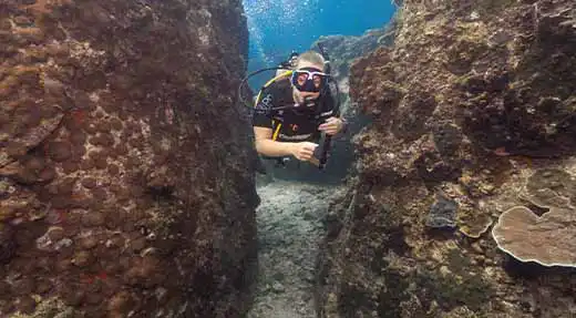 kohtaodiving.org-chronicles-air-consumption-koh-tao-diver-underwater-between-rock-swim