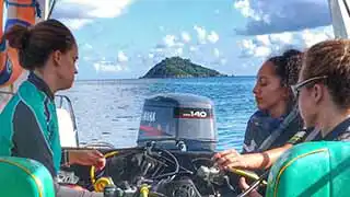 The coral tribe girls on the boat with dive equipment