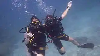 kohtaodiving.org-adventure-diver-happy-divers-underwater-hug Crystal Dive advanced adventure divers hugging underwater