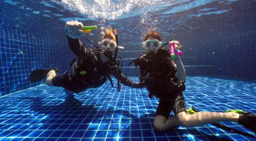 SSI Explorers participant and instructor playing with toys in the pool